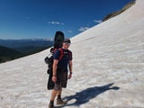 Justin Hiking in the summer with his snowboard - wearing the On A Limb trucker hat