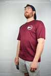 Model wearing the new maroon On A Limb shirt in front of a white background