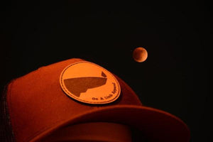 On A Limb Apparel trucker hat with the lunar eclipse in the background